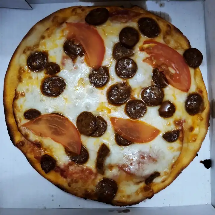 Une pizza au chorizo et à la tomate dans sa boîte Pili, prête à être emportée.